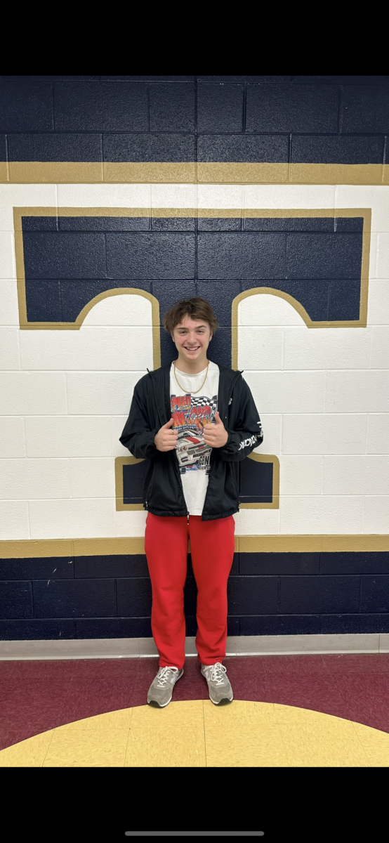 Brady McHenry stands in front of the Titan symbol. 